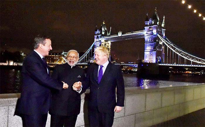 Britain's Prime Minister David Cameron (L) Prime Minister Narendra Modi (C) and Mayor of London Boris Johnson (R) hold hands in front of Tower Bridge in London on November 12, 2015. (AFP Photo)