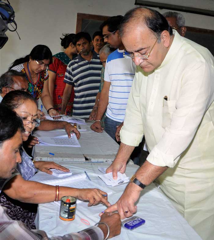 Senior BJP leader Arun Jaitley gets his finger marked with indelible ink prior to casting his vote at a polling station in Ahmedabad.