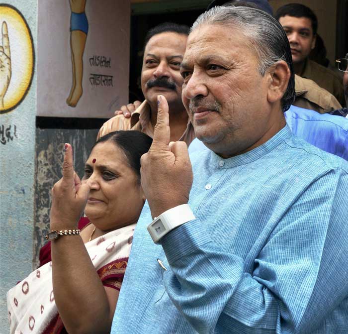 Narhari Amin, a former state minister who defected to the BJP after Congress denied him ticket to contest in the elections, casts his vote along with his wife at a polling booth in Ahmedabad.