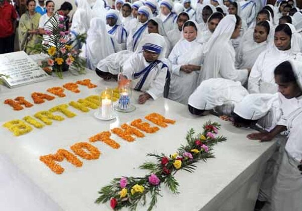 Missionaries of Charity nuns and volunteers kiss Mother Teresa's tomb as they celebrate her 99th birth anniversary at the Missionaries of Charity Mother House in Kolkata on August 26, 2009. Hundreds of nuns took part in the morning service to mark the day Mother Teresa was born August 26, 1910 in what is now Skopje, Macedonia.