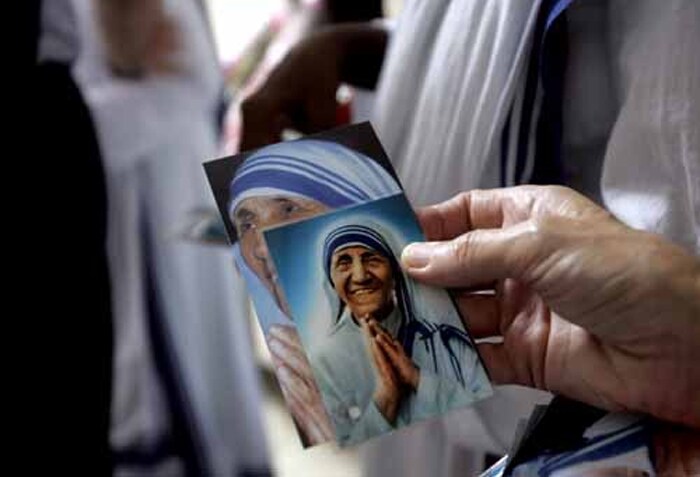 An unseen nun of the Missionaries of Charity holds a set of portraits of Mother Teresa for distribution. After Mother Teresa left the world, her efforts continued to be remembered and appreciated throughout the world. (AFP Photo)