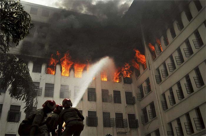 Firefighters spray jets of water to contain the fire. People were reported trapped in the upper floors of the building, with the fire department, police response teams, and navy pressed into rescue operations. (Photo courtesy: PTI)