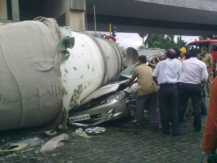 A cement mixture truck fell from a flyover bridge on to the road below, crushing a car in Mumbai on Sunday.<br><br>Two people, the car's driver and a traffic policeman, are reported have been seriously injured. The accident took place near the Andheri Goldspot Junction in Mumbai's western suburb.