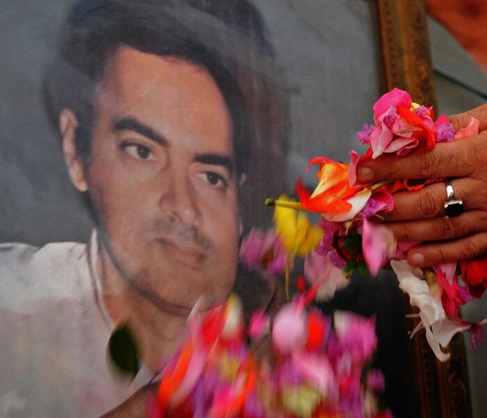 A Congress party supporter prepares to scatter petals while paying tribute to a portrait of slain Indian Prime Minister Rajiv Gandhi at a ceremony at Congress regional headquarters in Srinagar on August 20, 2009 to mark Gandhi's 65th birth anniversary. (AFP Photo)