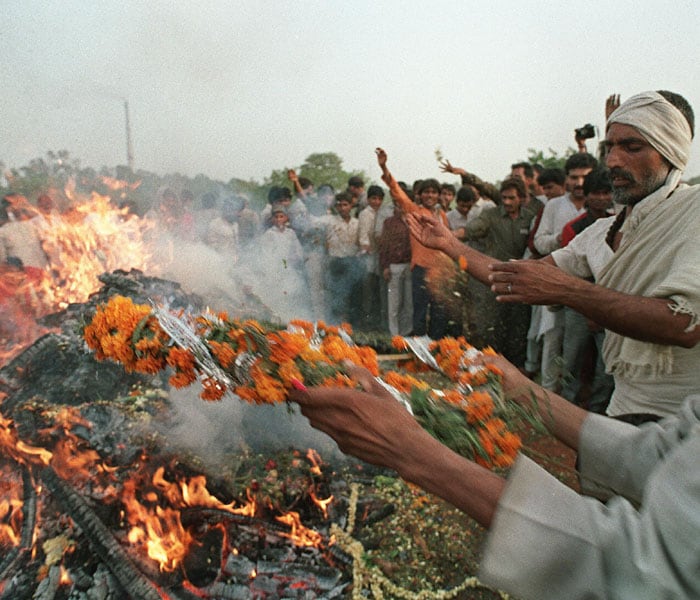 Mourners shown in photo dated May 24, 1991 throwing flowers on the burning funeral pyre of slain former Indian Prime Minister Rajiv Gandhi at Shakti Sthal on the banks of the holy Yamuna River. (AFP Photo)