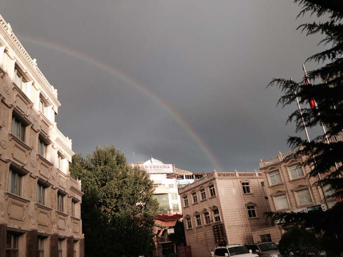 Rainbow in Dark Lhasa Sky. The contrast between the sky and the bright buildings brings out the unique Lhasa style of architecture.