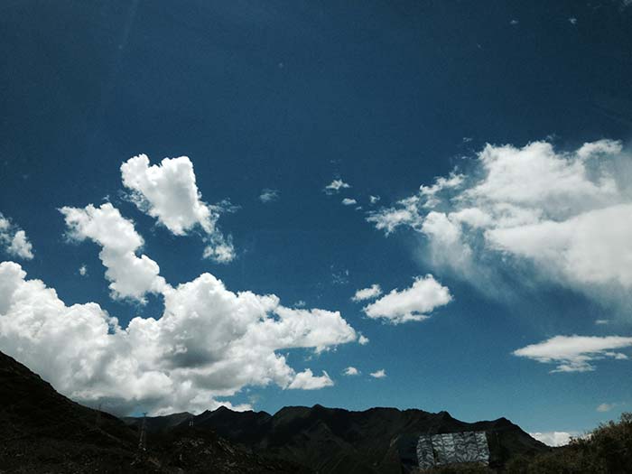 Towers supporting power cables can be seen at the farthest, highest reaches of the mountains.