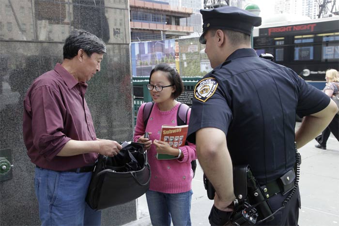 New York City police officers perform security check with hand-held radiation detector along the perimeter of the World Trade Centre. The police has increased security in the city ahead of the September 11 observance this Sunday. (AP Photo)