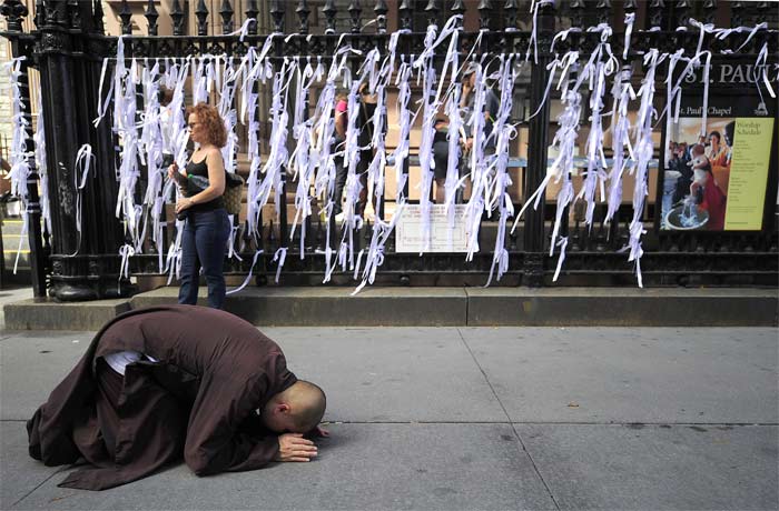 A Buddhist monk prays in front of "Ribbons of Remembrance" flying in the wind along St Paul's Chapel fence, tied by people to remember victims from the 9/11 World Trade Centre attacks, near Ground Zero in New York. (AFP Photo)