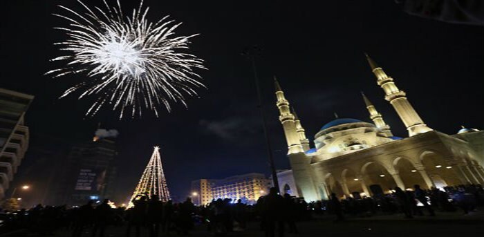 Lebanese watch a firework display during the New Year's celebrations at midnight in downtown Beirut