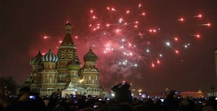 People photograph fireworks as they celebrate the New Year in Red Square in Moscow, Russia