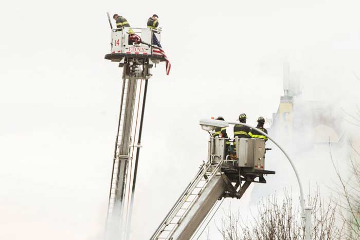 Firefighters from the Fire Department of New York respond to a five-alarm fire and building collapse.