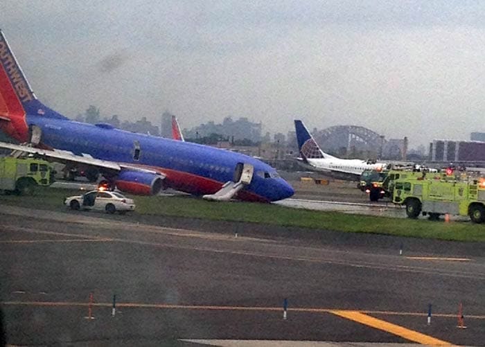 Emergency crews were seen spraying foam toward the front end of the plane on the tarmac. The Port Authority said the passengers exited the plane by using emergency chutes. <br><br>
Photo credit: AP