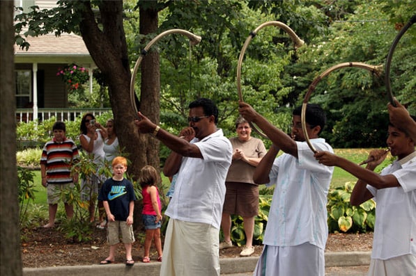 The blowing of the kumba horns bring neighbors out to watch. (NYT Photo)