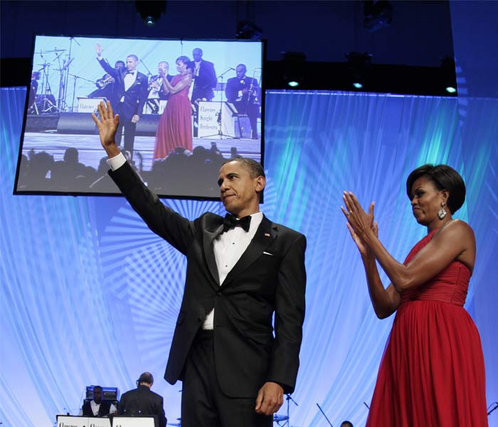 In a floor-length burgundy cocktail dress, the First Lady appeared to be at her romantic best. She applauded the President on stage and walked hand-in-hand with him. (AP Photo)