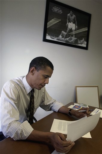 <b>Busy working:</b> In this July 22, 2004 file photo then-Democratic Senate nominee Barack Obama, working near a photo of a victorious Muhammad Ali standing over his challenger, reads through his keynote address that he is to deliver to the Democratic National Convention in Chicago. In the 17 minutes it took to deliver the speech Obama created a national buzz, and pundits and politicians began talking about him as a presidential candidate.