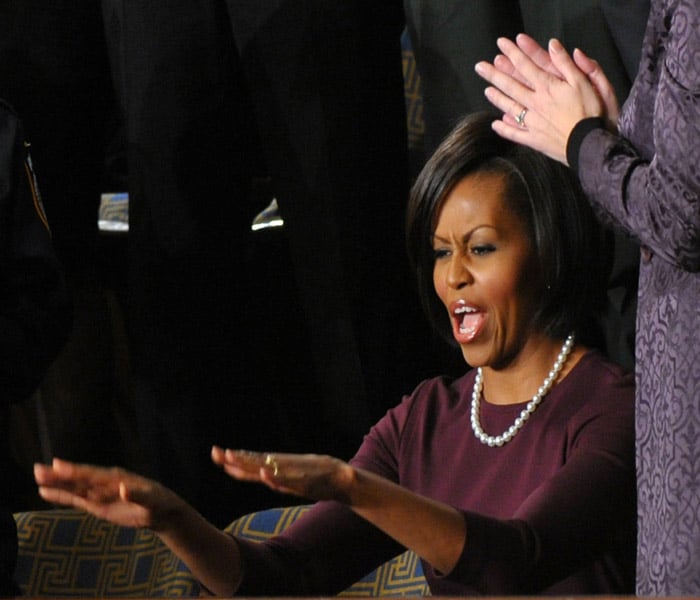 US First Lady Michelle Obama hails US President Barack Obama as he delivers his first State of the Union address. Obama declared that the worst of the economic storm had passed, but that a trail of devastation was left behind.(AFP Photo)