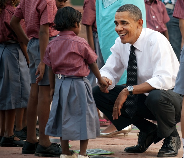 US President Barack Obama bends down to shake hands with a young child as he tours through Humayun's Tomb in New Delhi. (AFP Photo)