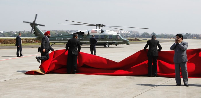 Strong winds played a bit of a spoilsport for the red carpet send off to the Obamas for Delhi as the gusts blew away the rug twice despite the best efforts of officials who finally decided to get rid of it to avoid an embarrassment. (AP Photo)