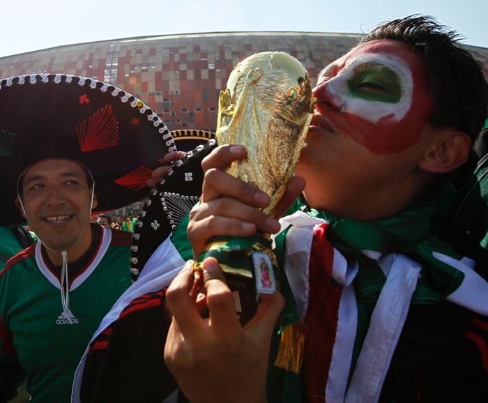 <b>WISH THIS WAS THE REAL THING: </b>A supporter of the Mexican team kisses a mock World Cup trophy, prior to the start of the match between South Africa and Mexico. (AP Photo)