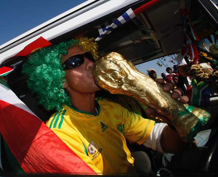 <b>AND ANOTHER..... </b>A soccer fan kisses a replica of the World Cup trophy outside a shopping mall in Soweto, Johannesburg. (AP Photo)