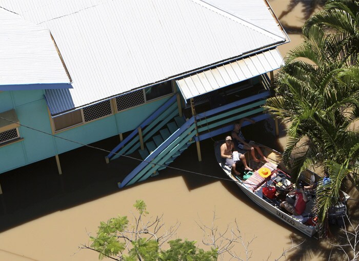<b>Waiting for help:</b> In this Tuesday, Jan. 4, 2011 photo, locals in their boat are tied to their house in the floodwaters in Depot Hill, Rockhampton, Australia. Floods cut air, rail and road links to an Australian coastal city and are now threatening its sewage plant. (AP Photo)