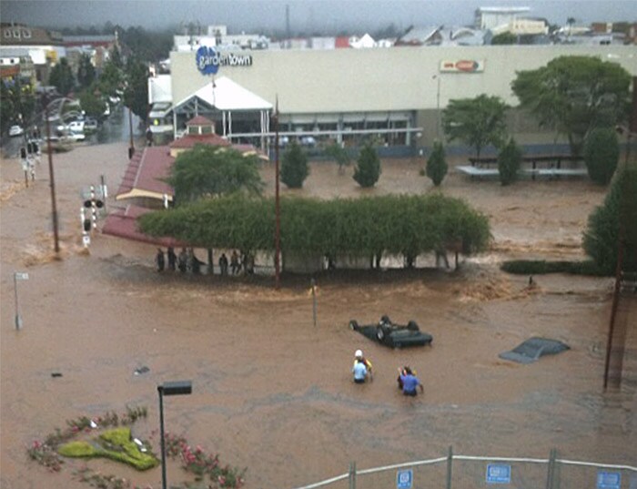 <b>The art of survival:</b> People wade up to their waists in water at a street corner in Toowoomba, Australia, as a flash flood carries vehicles past them Monday, Jan. 10, 2011. (AP Photo)