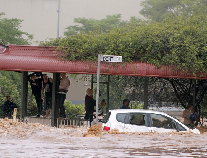 <b>Touch and go:</b> People cling to railings and metal fences on a flooded street in Toowoomba, Australia, during a flash flood Monday, Jan. 10, 2011. Flash floods swept through the northeastern Australian community, trapping people in cars and leaving some clinging to trees as relentless rains brought more misery to a region battling its worst flooding in decades. (AP Photo)