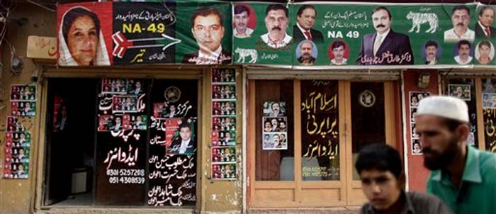 Offices are decorated with posters showing candidates of Pakistan People's Party (PPP), left, and candidates of Pakistan Muslim League-N party headed by Nawaz Sharif, right, in Islamabad.