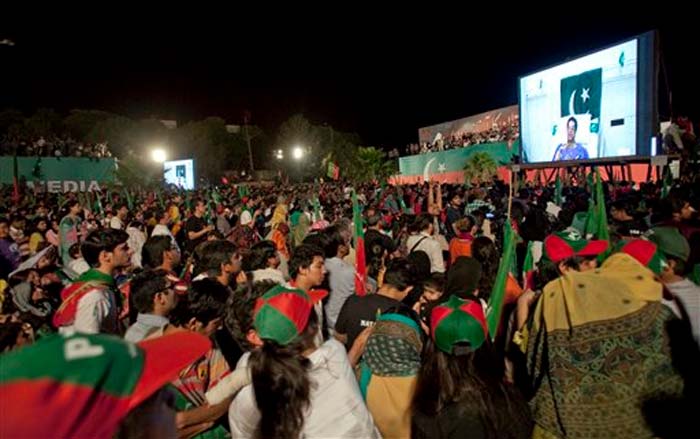 Pakistan Tehreek-e-Insaf party Chairman Imran Khan is seen on screen, as he addresses through a video link from his recovery bed, to an election campaign rally in Islamabad, Pakistan on Thursday.