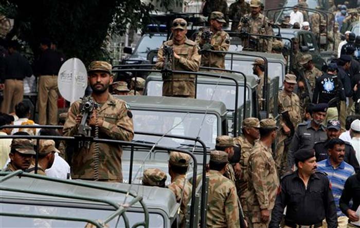 Pakistani army soldiers, and police officers guard outside the city court where election materials are delivered to be dispatched to polling stations in Lahore.