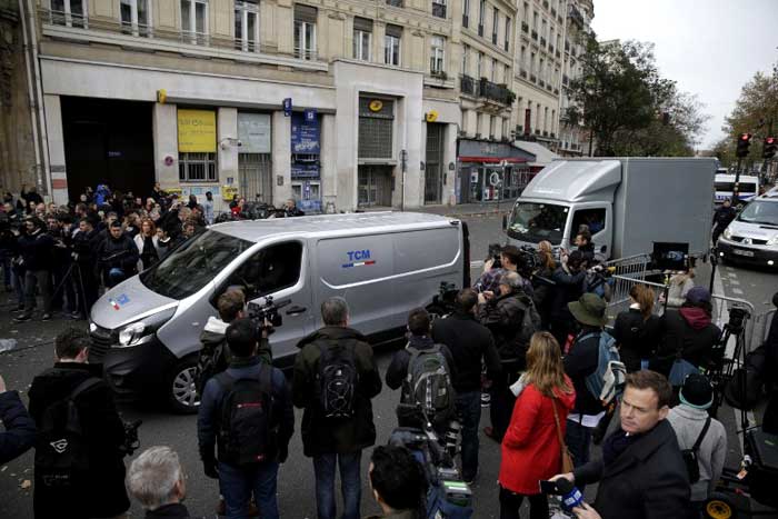 Undertakers vehicles arrives near what appears to be blood stains near the Bataclan theatre in the 11th district of Paris on November 14, 2015. (AFP Photo)