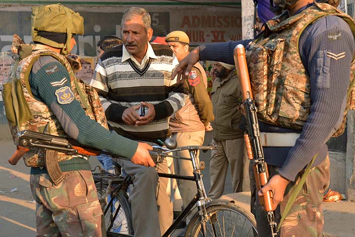 Security personnel check airforce employees at a road leading to an airforce base in Pathankot on January 3, 2016, during an operation to 'sanitise' the base following an attack by gunmen.