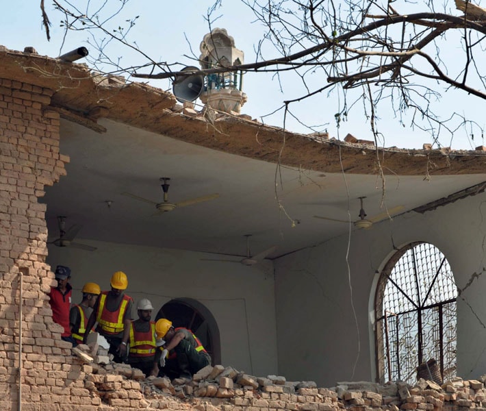 Pakistani volunteers search for victims of the suicide car bomb blast in Peshawar. The targeted area also housed the office of the Crime Investigation Agency (CIA). (AFP)