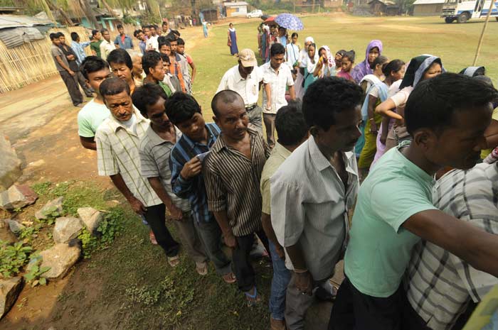 Voters stand in a queue to cast their votes at a polling station in Meghalaya.