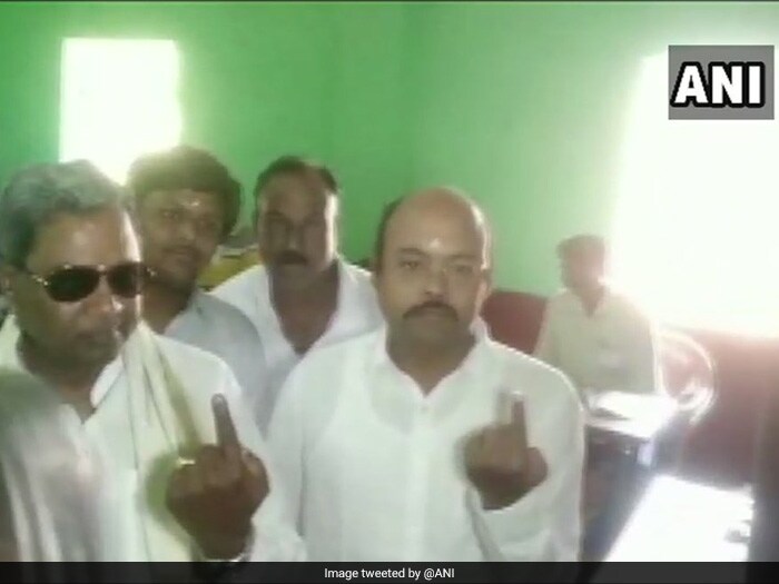 Former Karnataka Chief Minister Siddaramaiah and his son Yathindra Siddaramaiah cast their votes at a polling booth in Mysuru.