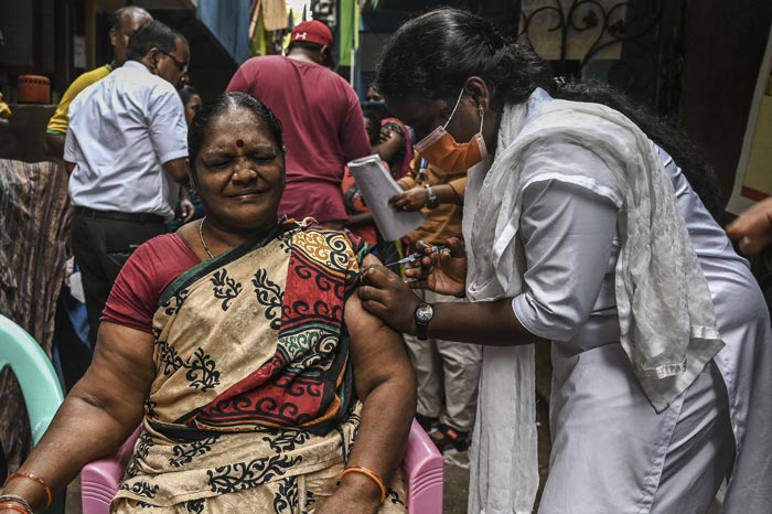 A health worker inoculates a man with a dose of the Covaxin vaccine against the Covid-19 coronavirus at a health centre in New Delhi. India administered its billionth Covid-19 vaccine dose on October 21, according to the health ministry, half a year after a devastating surge in cases brought the health system close to collapse.