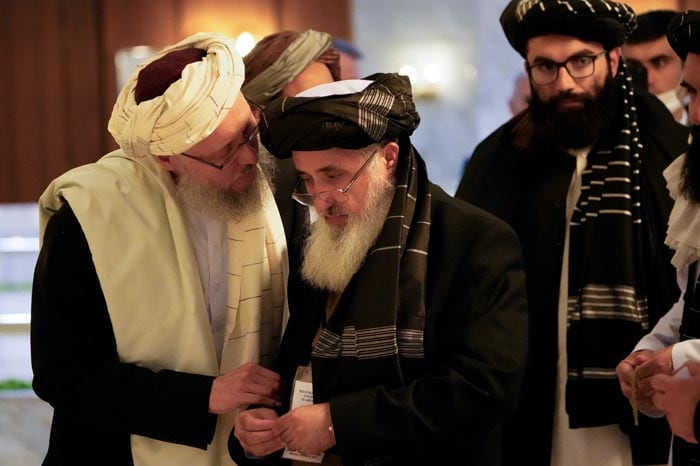 Head of the Taliban delegation, deputy Prime Minister Abdul Salam Hanafi (L) speaks with acting Foreign Minister of Afghanistan, Taliban official Amir Khan Muttaqi during an international conference on Afghanistan in Moscow.