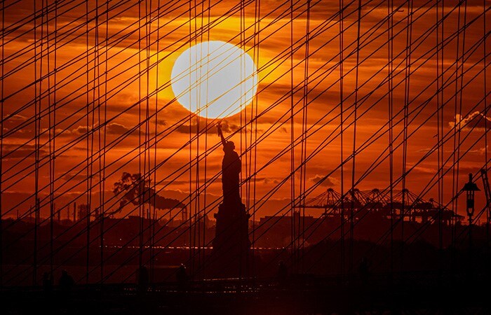 The Statue of Liberty is seen during sunset in New York City.