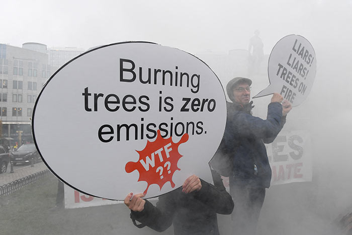 Environmental activists demonstrate near a stack of 30 wooden logs, each 1.5 meters long, near the European Parliament building in Brussels.