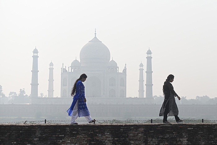 Visitors walk at the Mehtab Bagh complex behind the Taj Mahal.