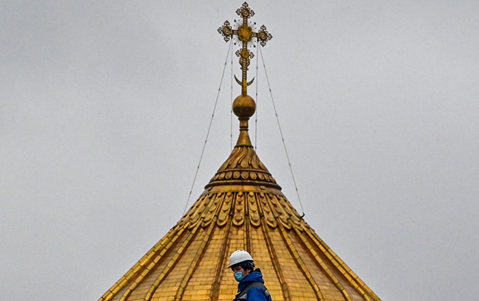 A municipal worker wearing a face mask crosses a bridge near the Christ the Saviour catherdal in central Moscow.