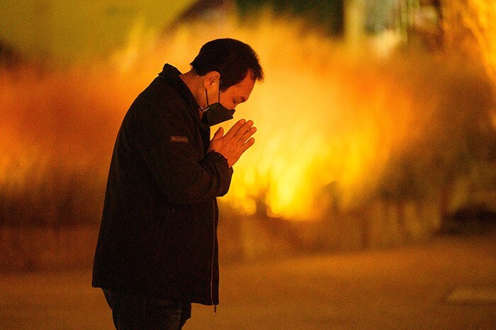 A man prays at Jogyesa temple in Seoul, the night before more than half a million students will sit for the annual high-stakes university entrance exam.