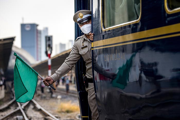 A conductor looks out from a steam train as it leaves Bangkok Railway Station for a trip to mark the birthday of Thailand's late king Bhumibol Adulyadej in Bangkok.