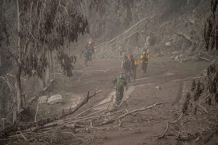 Rescue personnel search for villagers in an area covered in volcanic ash at Sumber Wuluh village in Lumajang, Indonesia.