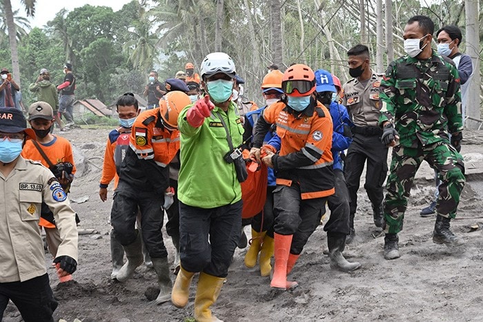 Members of a search and rescue team carry a dead body in Lumajang following a volcanic eruption from Mount Semeru.