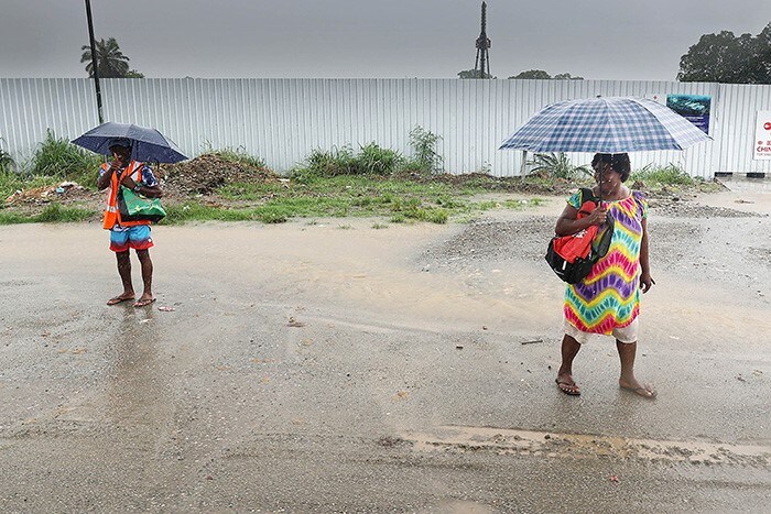 People walk in the rain in Honiara, Solomon Islands.