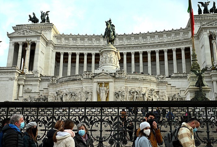 Visitors wearing face masks line up at the entrance to the Altare della Patria monument in Rome.