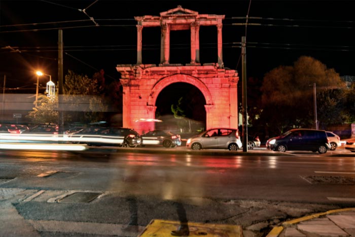 Hadrian's Arch lit orange, a message against the crime of femicide and gender-based violence in Athens, Greece.