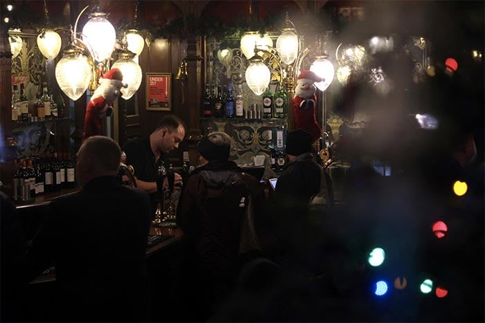 A barman inside a dark pub in central London, Britain.